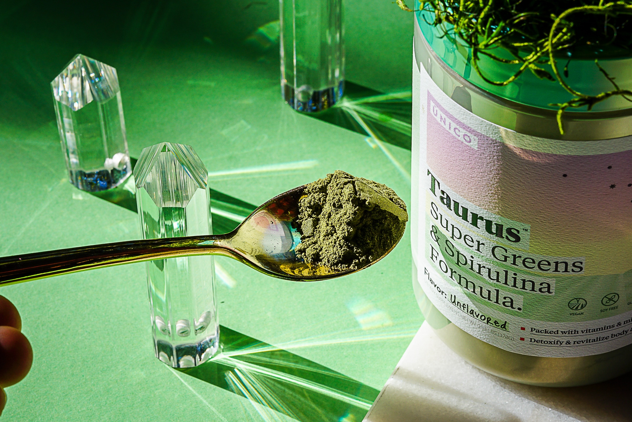 spoonful of chlorella powder with green background and crystals