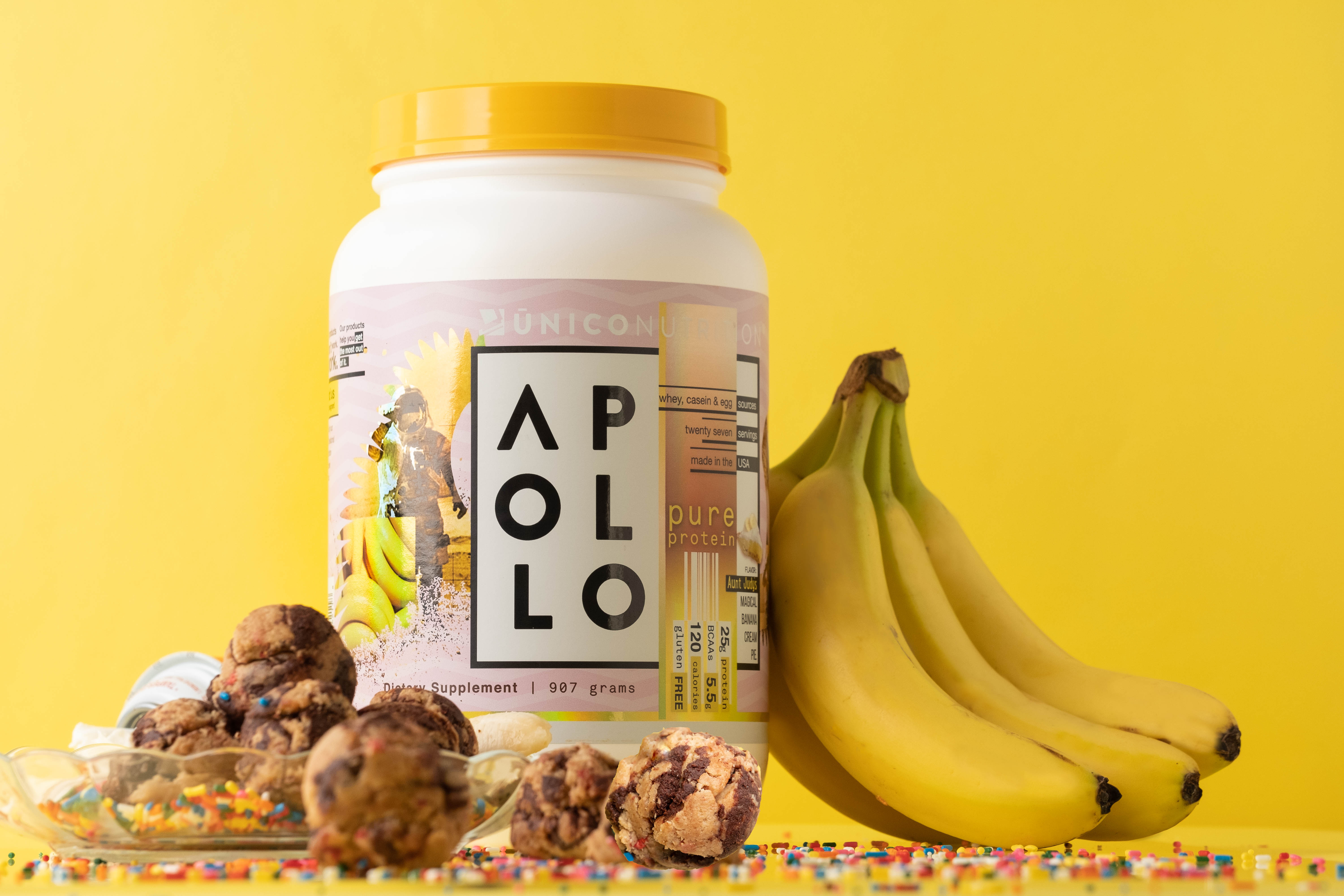unico apollo banana cream protein with protein balls and bunch of bananas