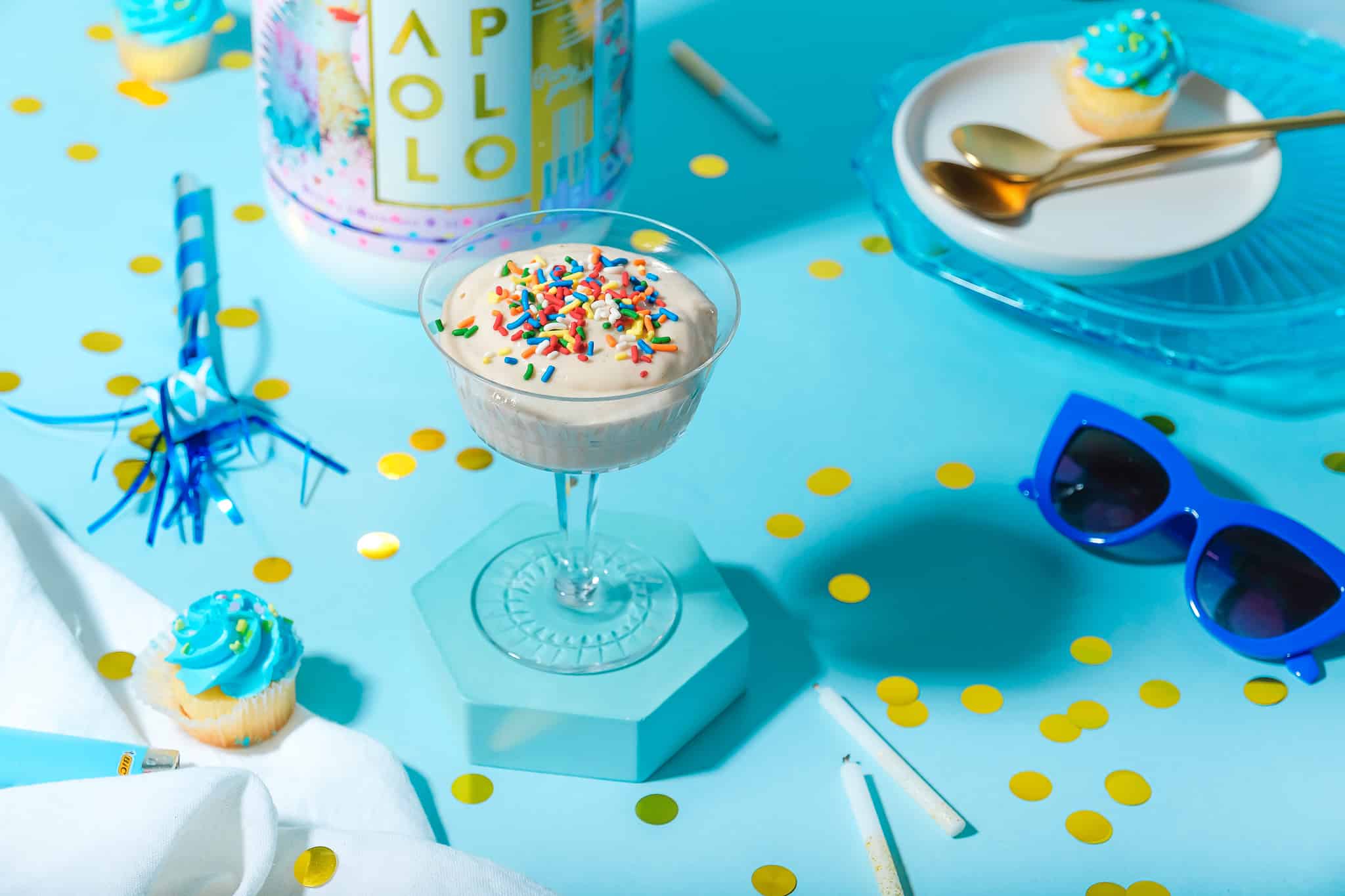 glass of protein fluff with birthday cake props overhead flat-lie style